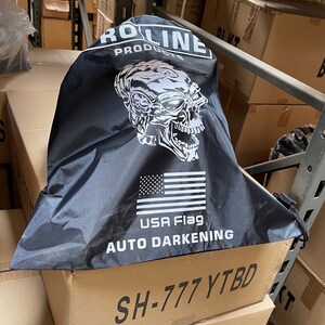 May include: Black drawstring bag with a white skull graphic, the words "ROLINE PRODUCTS", "USA Flag", and "AUTO DARKENING", and the code "SH-777 YTBD".