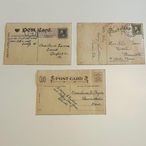 May include: Three vintage postcards with handwritten messages and postage stamps. The postcards are tan with black ink and feature the words "Post Card" and various addresses and greetings.