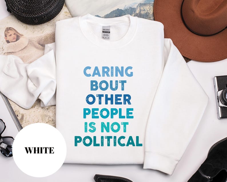 Bold statement sweatshirt with the phrase Caring About Other People Is Not Political, promoting kindness, activism, and human rights.