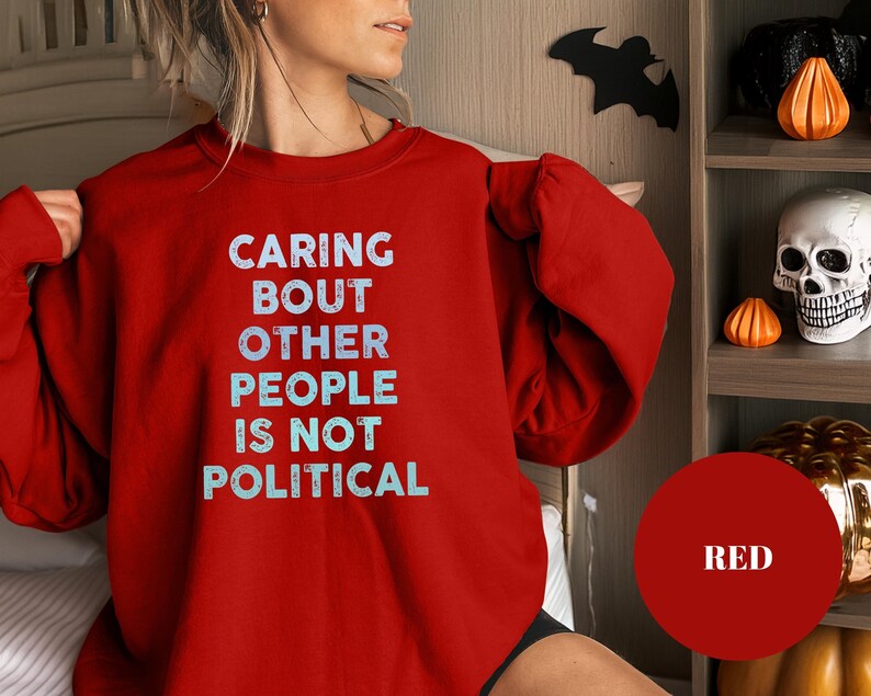 Bold statement sweatshirt with the phrase Caring About Other People Is Not Political, promoting kindness, activism, and human rights.