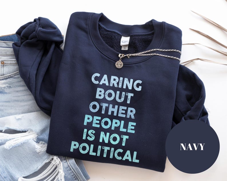 Bold statement sweatshirt with the phrase Caring About Other People Is Not Political, promoting kindness, activism, and human rights.