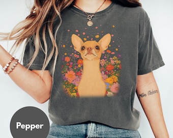 May include: Dark gray t-shirt featuring a tan chihuahua with large ears, surrounded by colorful flowers. The dog's portrait is centered on the shirt. The word "Pepper" is printed on a gray circle at the bottom.