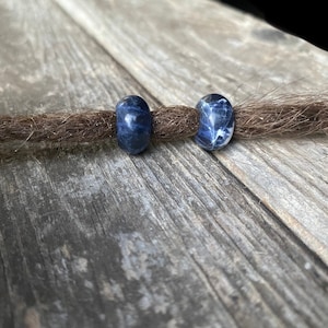 Puede incluir: Dos cuentas redondas de piedra azul y blanca para rastas. Las cuentas tienen un patrón de mármol.