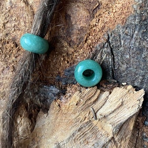 Op de afbeelding: Twee groene jade donut kralen voor dreadlocks of haarstijlen.
