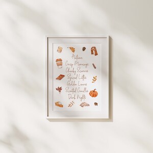 May include: A white framed print with a watercolor illustration of autumnal elements. The text reads "Autumn, Crisp Mornings, Chunky Scarves, Spiced Lattes, Golden Leaves, Scented Candles, Dark Nights".