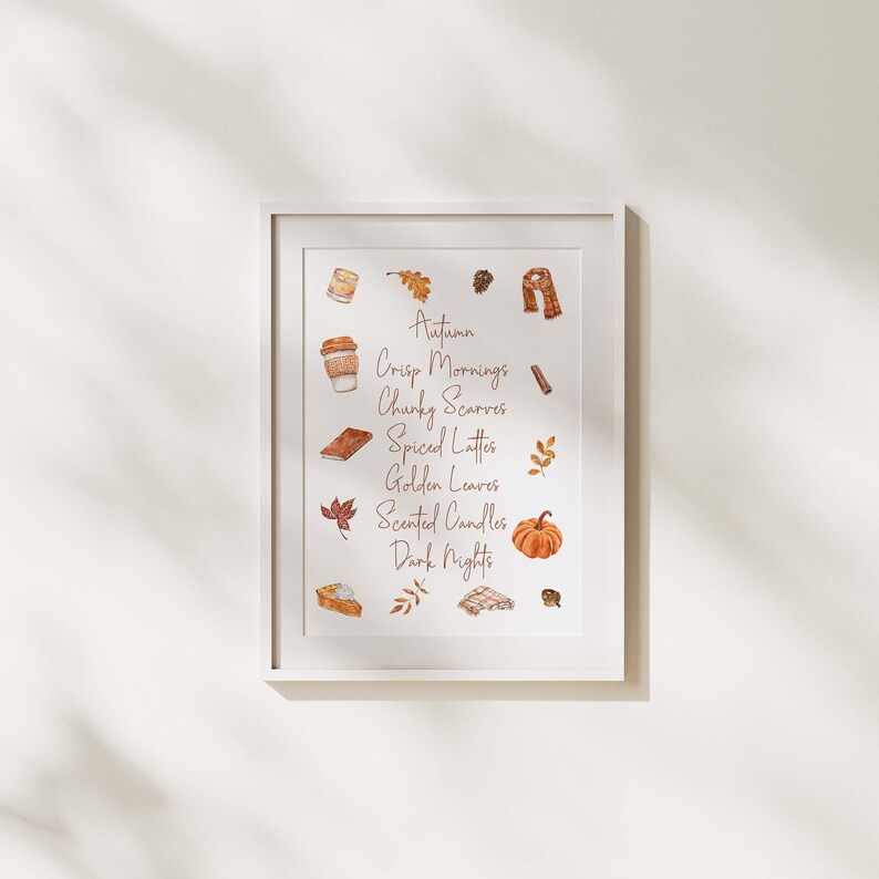 May include: A white framed print with a watercolor illustration of autumnal elements. The text reads "Autumn, Crisp Mornings, Chunky Scarves, Spiced Lattes, Golden Leaves, Scented Candles, Dark Nights".