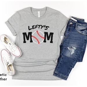 May include: Grey t-shirt with the text "Lefty's Mom" in black with a baseball graphic in red and white.