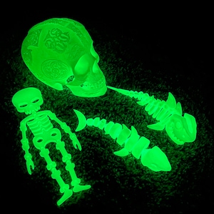 May include: A set of glow-in-the-dark skeleton decorations, including a skull, a skeleton, and two fish skeletons. The decorations are made of a translucent plastic and are a bright green color.