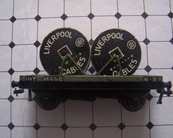 May include: A black model train car with two spools of cable on top. The spools are labeled "Liverpool Cables" and have a green string wrapped around them. The car has a black and green body with the number "M466" printed on the side.