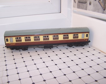 May include: A brown and cream toy train car with a green roof and six windows. The car has the number "W 15862" printed on the side.