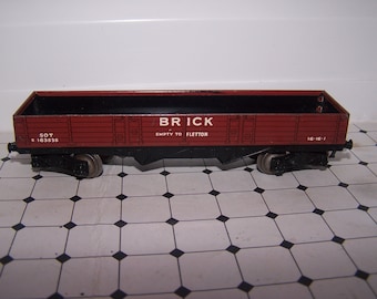 May include: A red toy train wagon with black wheels and the words "BRICK EMPTY TO FLETTON" printed on the side. The wagon has a black interior and the number "50T" and "R 163535" printed on the side. The wagon also has the number "16-16-1" printed on the side.