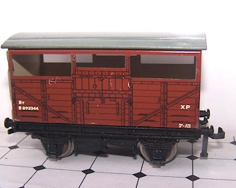 May include: A model railway goods brake van with a red body, a grey roof, and a black chassis. The side features printed white text reading 8T, B 893344, XP, and 7-13. The model includes metal wheels, buffers, and a coupling hook on the end.