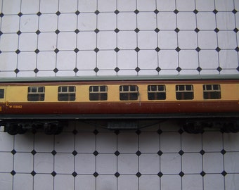 Op de afbeelding: Een bruine en crèmekleurige treinwagon met een groen dak en zes ramen. De wagon heeft de tekst "W 15862" aan de zijkant.