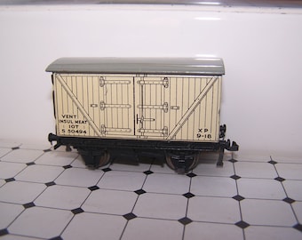 May include: A vintage toy train car, a white and brown boxcar with black wheels and a gray roof. The car has the text "VENT INSUL MEAT IOT S 50494 XP 9-18" printed on the side.