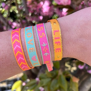 Happy colors woven text ribbon bracelets. Life is beautiful, happiness, love, arrow pattern. Friendship