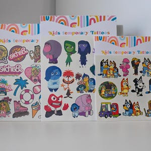 May include: Three sheets of temporary tattoos for kids. The first sheet features Barbie characters and logos. The second sheet features characters from the movie Inside Out. The third sheet features characters from the show Bluey.