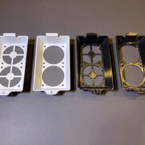 May include: Four rectangular, open-top containers with circular cutouts and gray inserts. Two are white, and two are black with gold accents. The containers have a series of small holes along the bottom edge.