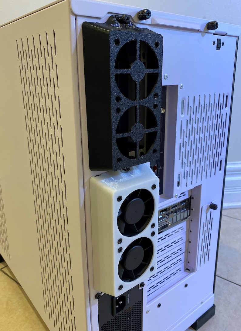 May include: A computer case with a black fan assembly mounted on the side. The case is light purple with ventilation slots. The fan assembly has two black fans and a white housing. The case also has a power supply.