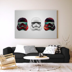 Op de afbeelding: Drie geometrische stormtrooperhelmen op een rij. De helmen zijn wit, rood en blauw met een galaxy-patroon.