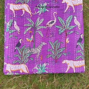 K&ouml;nnte beinhalten: Lilafarbener Kantha-Steppdecke mit einem schwarz-wei&szlig;en Zebra, Tukanen, Flamingos, Leoparden und Palmen. Die Steppdecke hat ein wei&szlig;es Steppmuster.