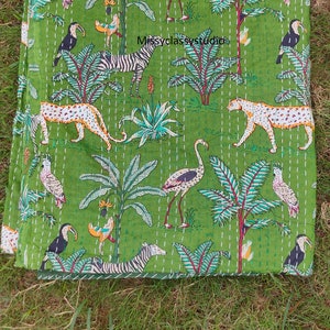 K&ouml;nnte beinhalten: Gr&uuml;ne Kantha-Steppdecke mit einem Muster aus Zebras, Leoparden, Flamingos, Tukanen und Palmen. Die Decke ist handgen&auml;ht und hat einen Vintage-Look.