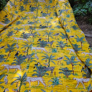K&ouml;nnte beinhalten: Gelbe Kantha-Steppdecke mit einem Muster aus Zebras, Leoparden, V&ouml;geln und Palmen. Die Decke ist aus Baumwolle und hat ein handgesticktes Design.
