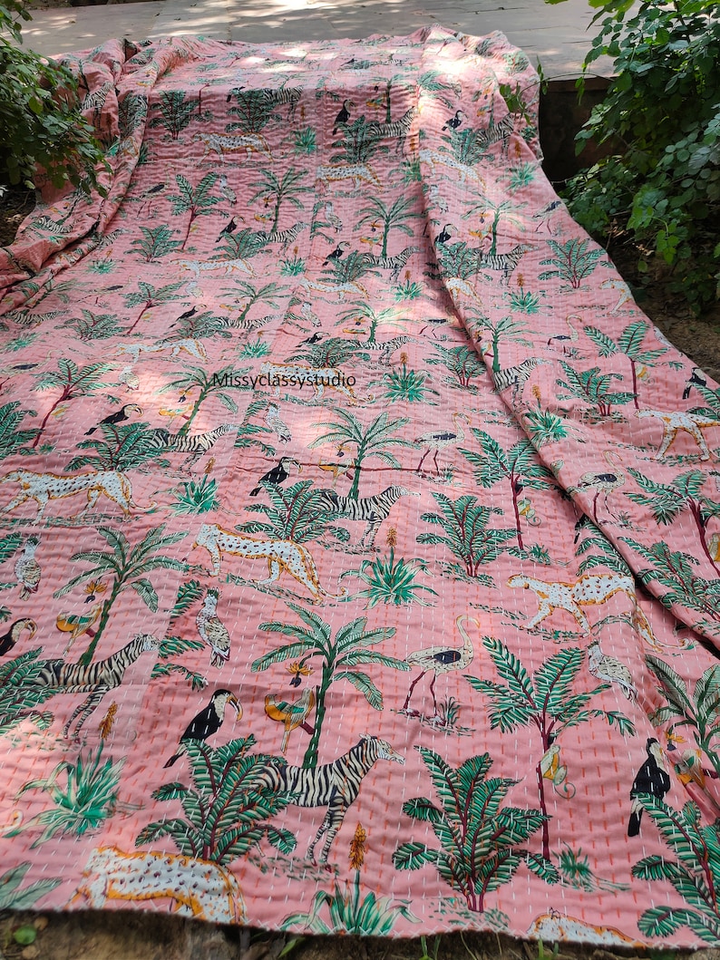 K&ouml;nnte beinhalten: Rosa Kantha-Steppdecke mit Dschungel-Druck, der Zebras, Leoparden, V&ouml;gel und Palmen zeigt. Die Decke ist aus Baumwolle und hat ein handgesticktes Design.