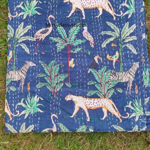 K&ouml;nnte beinhalten: Eine blaue Kantha-Steppdecke mit einem farbenfrohen Dschungel-Druck mit Zebras, Leoparden, V&ouml;geln und Palmen. Die Steppdecke ist aus Baumwolle und hat ein handgesticktes Design.