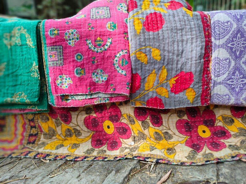 May include: Four kantha quilts in various colors and patterns, including pink with geometric designs, gray with floral designs, green with paisley designs, and a beige quilt with floral designs.