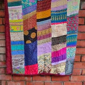 May include: A colorful patchwork quilt made from various fabrics, featuring a variety of patterns and colors, including red, blue, green, yellow, and purple. The quilt is hand-stitched and has a unique, rustic look.