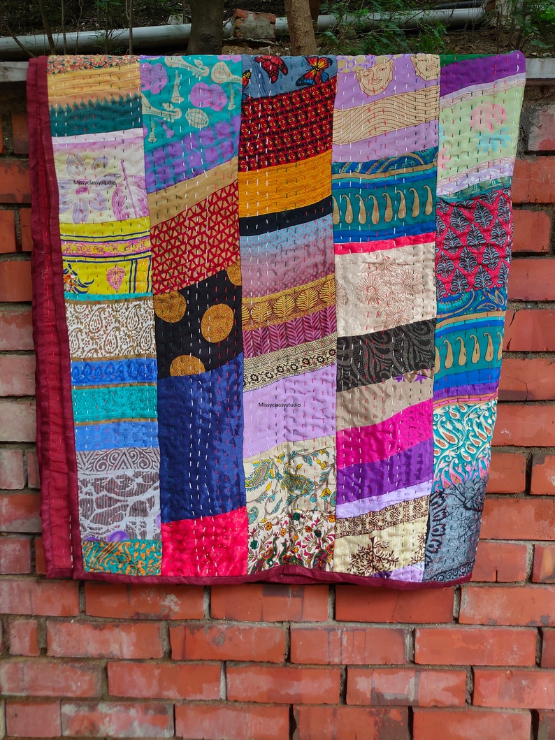 May include: A colorful patchwork quilt made from various fabrics, featuring a variety of patterns and colors, including red, blue, green, yellow, and purple. The quilt is hand-stitched and has a unique, rustic look.
