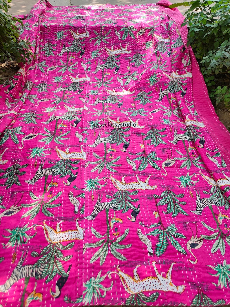 K&ouml;nnte beinhalten: Rosa Kantha-Steppdecke mit Dschungel-Druck, der Leoparden, Zebras und Palmen zeigt. Die Decke ist handgen&auml;ht und hat ein traditionelles indisches Design.