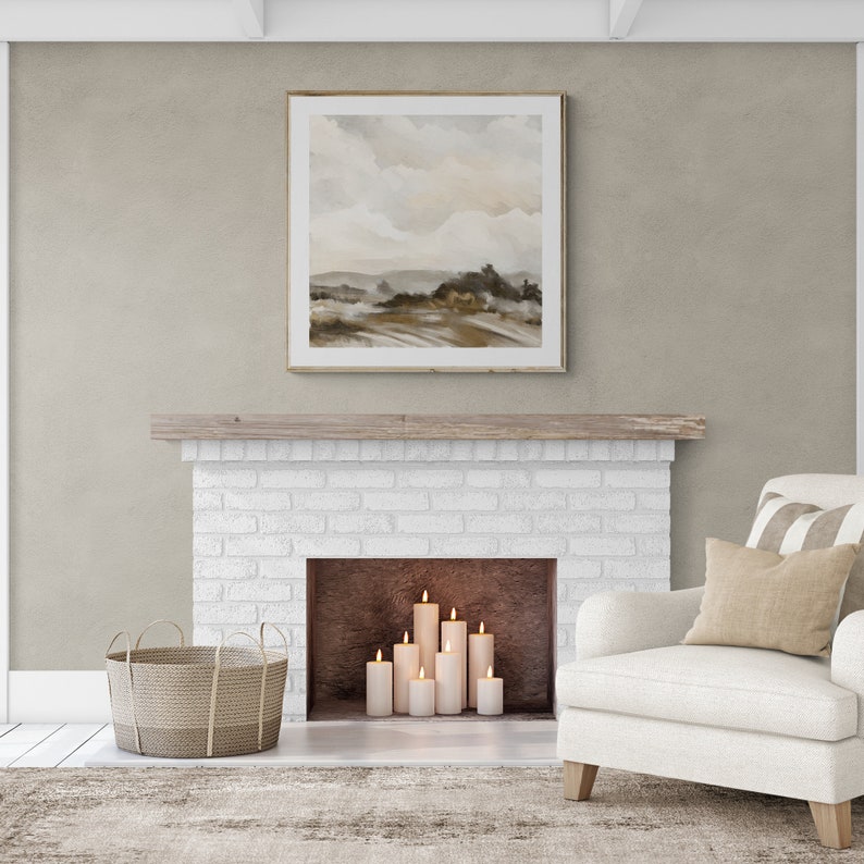 May include: A white brick fireplace with a wooden mantel and a framed landscape painting above it. The fireplace has a black hearth and is decorated with lit candles.
