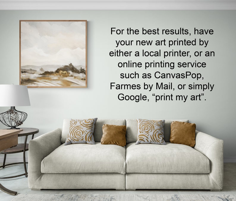 May include: A white couch with three throw pillows, one with a gold swirl pattern, one with a solid gold color, and one with a brown swirl pattern. The couch is in front of a white wall with a framed painting of a landscape scene and text that reads: "For the best results, have your new art printed by either a local printer, or an online printing service such as Canvas Pop, Frames by Mail, or simply Google, "print my art"."