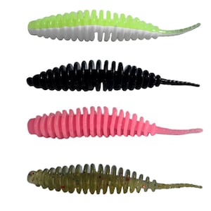 May include: Four soft plastic fishing lures arranged vertically. The top lure is neon green and white, the second is solid black, the third is bright pink, and the bottom lure is translucent olive green with small embedded glitter particles.