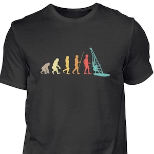 Peut inclure: Un t-shirt noir avec un graphique vintage représentant l'évolution des humains, se terminant par une personne faisant de la planche à voile. Le graphique est dans des tons d'orange, jaune, vert, bleu et rouge.