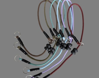May include: A collection of six dog leashes in various colors, including brown, green, blue, purple, and burgundy. Each leash features a loop handle, a metal ring, and black rubber stoppers. The leashes are made of braided rope.