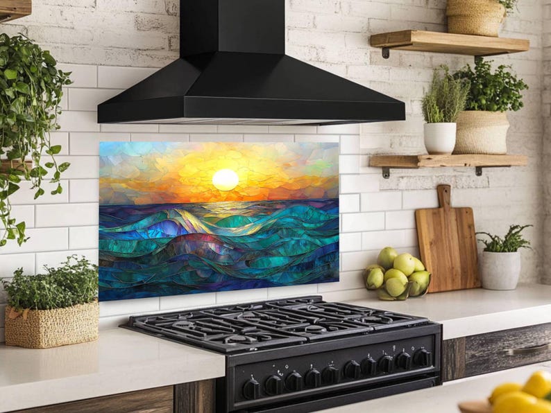 A stained-glass style backsplash featuring an ocean sunset with rolling waves is set on a white subway tile wall. It sits beneath a black hood and behind a black range, flanked by open shelves with plants and fruit.