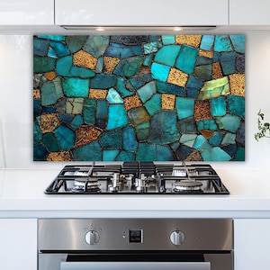 May include: A decorative kitchen backsplash featuring a mosaic design. The mosaic is composed of irregularly shaped tiles in shades of teal, turquoise, and gold. The tiles are arranged to create a visually appealing pattern, adding a touch of elegance to the kitchen.