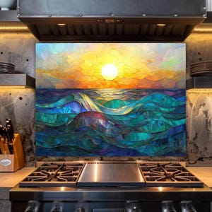 A stained-glass style backsplash featuring an ocean sunset with rolling waves is illuminated by warm under-cabinet lighting. It is set against a textured industrial wall behind a professional stainless steel range, flanked by a knife block and open shelving.