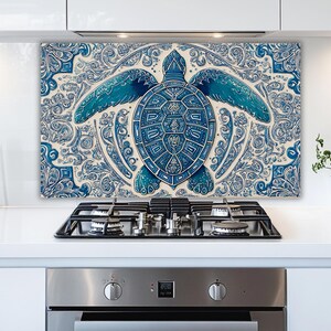 May include: A blue and white decorative kitchen backsplash featuring a detailed sea turtle design. The turtle is centered on a patterned background, with the design in shades of blue and white. The backsplash is mounted above a black stovetop.