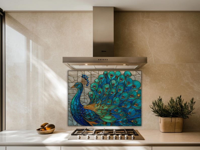 Vibrant peacock stained-glass backsplash in shades of teal and blue, mounted behind a professional gas range in a kitchen with beige marble-textured walls and a stainless steel range hood.
