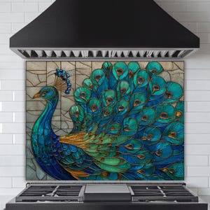 Vibrant peacock stained-glass backsplash in shades of teal and blue, mounted behind a professional black gas range in a kitchen with white subway tile walls and a black tapered range hood.