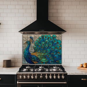 Vibrant peacock stained glass kitchen backsplash with shades of blue and teal. The artistic panel is mounted behind a professional black gas range in a kitchen with white subway tile walls and a black tapered range hood.
