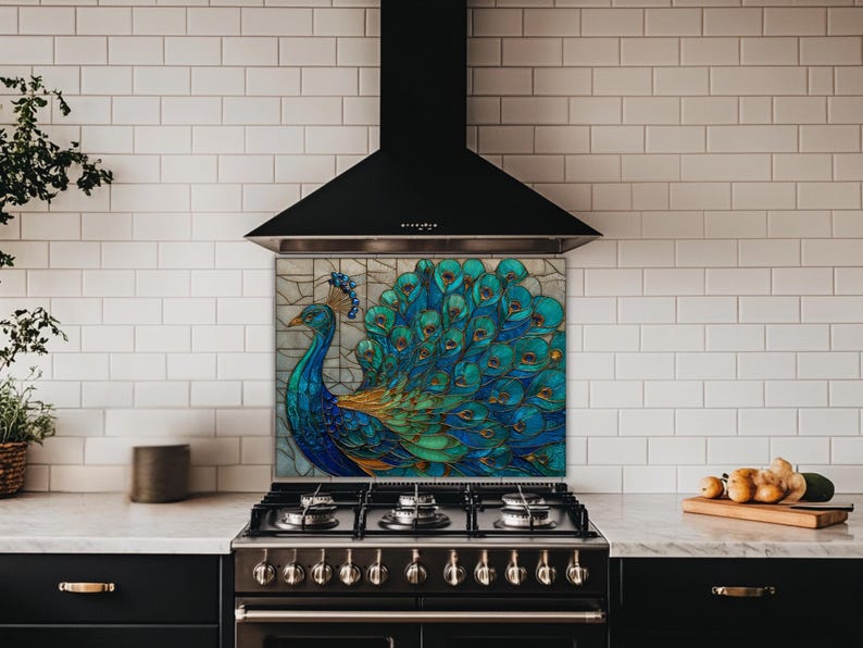 Vibrant peacock stained glass kitchen backsplash with shades of blue and teal. The artistic panel is mounted behind a professional black gas range in a kitchen with white subway tile walls and a black tapered range hood.