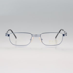 May include: Silver-toned metal rectangular eyeglasses with a thin frame and clear lenses. The brand name "F.A.S.H." is printed on the right temple.