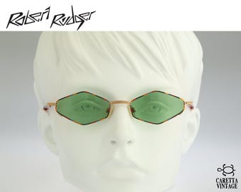 May include: Robert Rudger sunglasses featuring diamond-shaped lenses with light green tinting. The frames are gold-toned metal with a multi-colored patterned rim around the lenses. The design includes a thin bridge and slender temples.