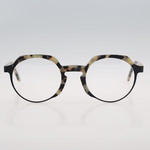 May include: A pair of tortoiseshell eyeglasses with round lenses and black frames.