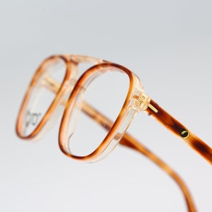 May include: Tortoise shell eyeglasses with clear lenses and gold accents.