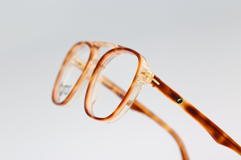 May include: Tortoise shell eyeglasses with clear lenses and gold accents.